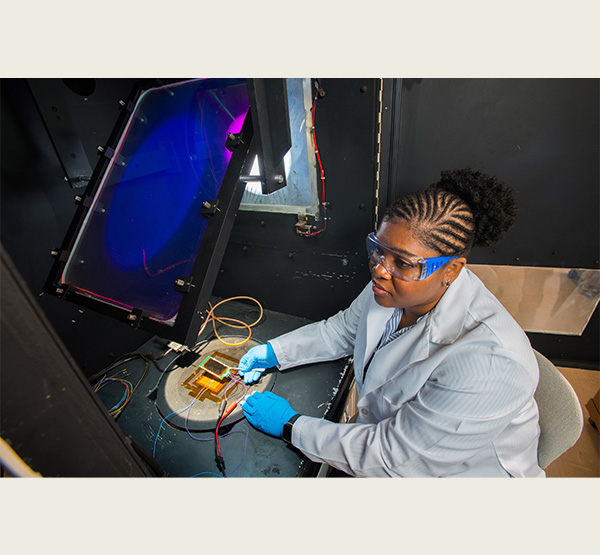 Lyndsey McMillon-Brown measures a solar cell's electrical output when exposed to simulated sunlight