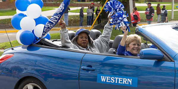 A car representing the Western College Alumnae Association rides in the Homecoming parade in 2023.