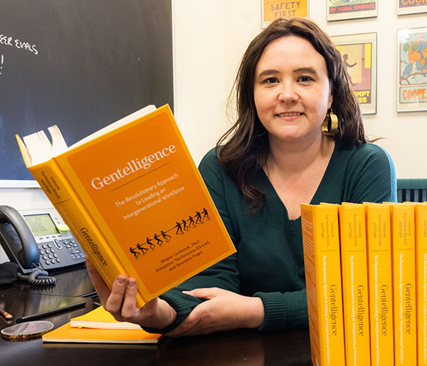 Megan Gerhardt holds her book Gentelligence at her desk