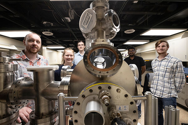 Perry Corbett, assistant professor of Physics, left, stands with students Sara McGinnis, Carter Wade, Lakshan Don Manuwelge Don, and Nate Price around the newly donated ultra-high vacuum scanning tunneling microscope.