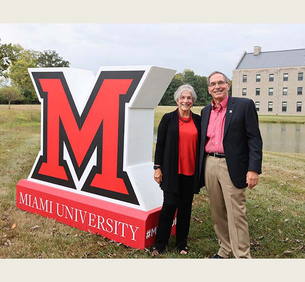 Sharon and Graham Mitchell stand next to large M and Western Upper POnd