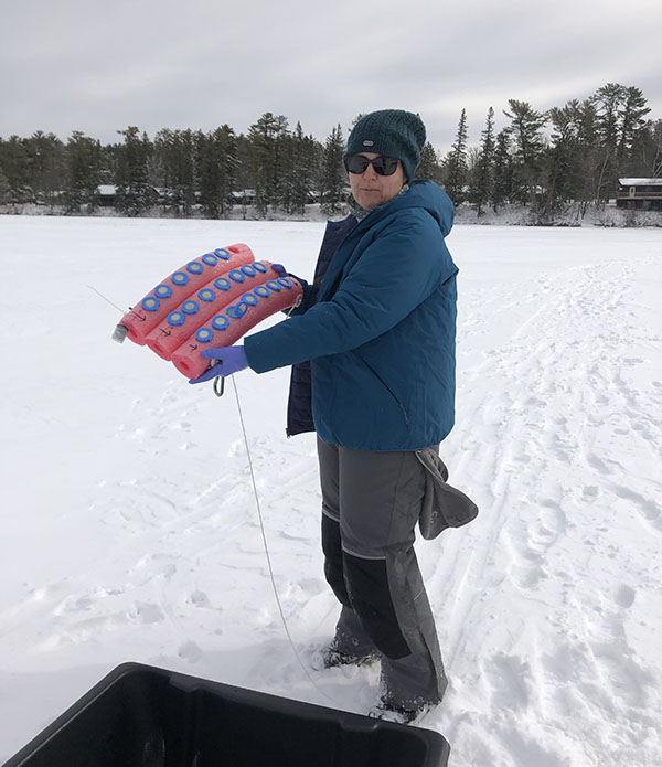 Lesley Knoll deploys an experiment at ice-covered Lake Itasca Lake