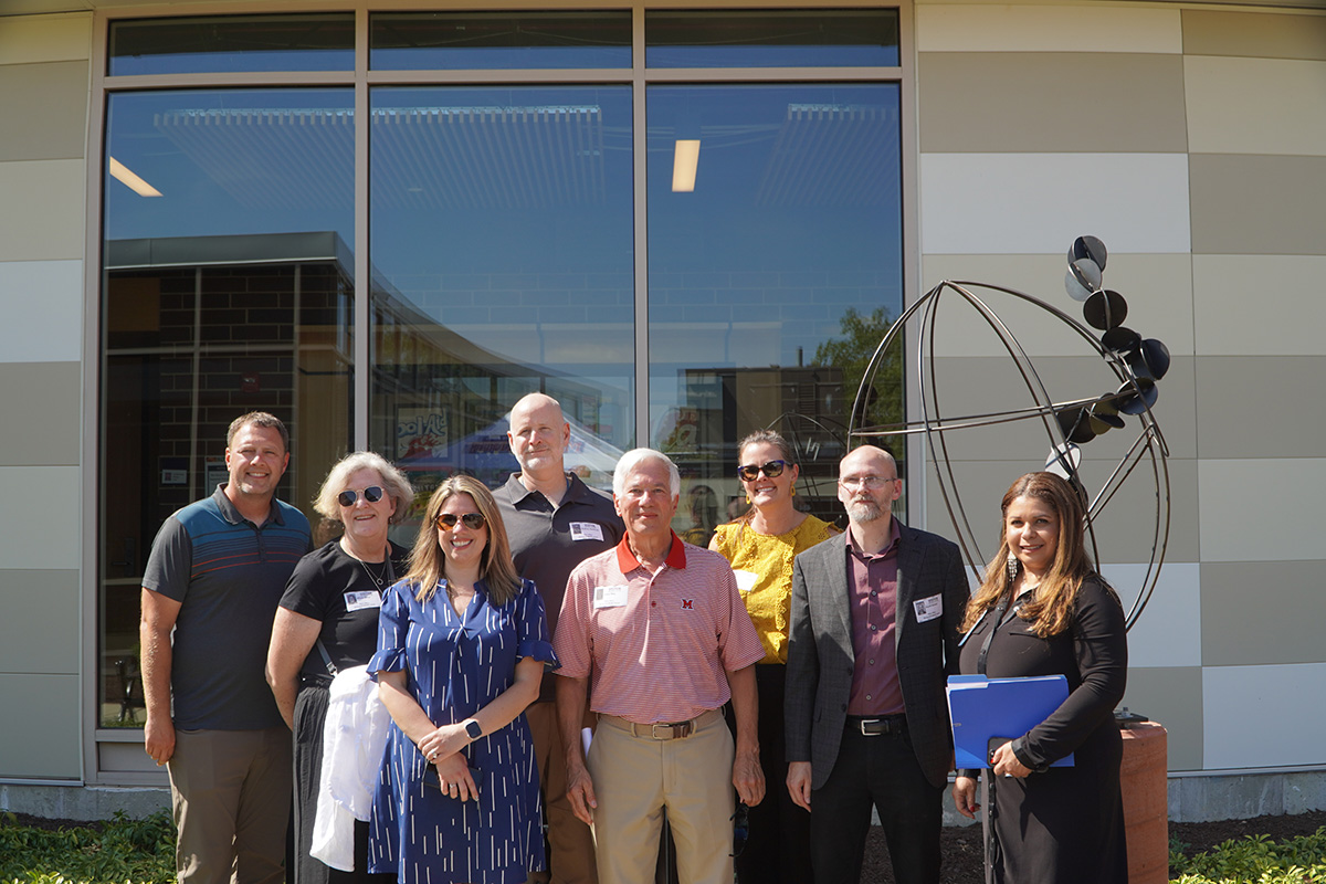 Representatives from Miami University and Marquardt Middle School pose in front of a recently installed sculpture, the result of a collaboration between the schools.