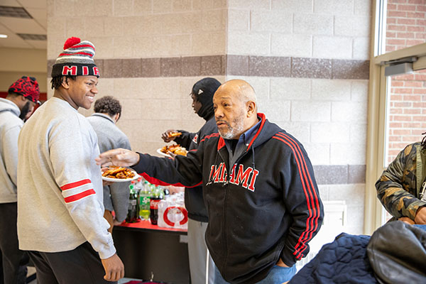 Rodney Coates, right, talks with members of the Miami University football program on Wednesday, Dec. 11, at Gross Center.