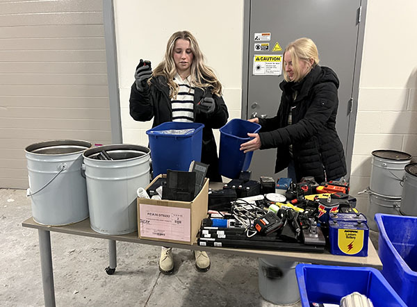 Alex Miller and Annabel Dechant sort batteries at the materials recycling facility