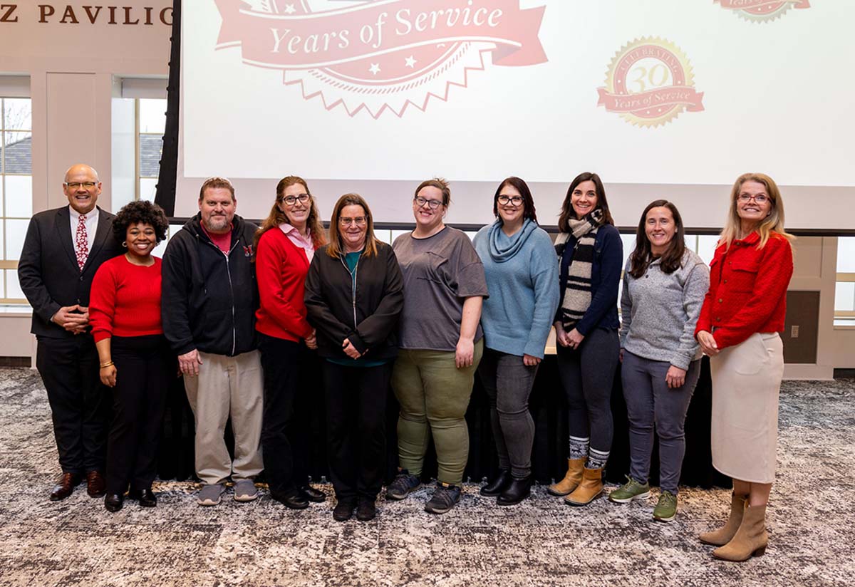 15 years of service group poses in front of screen