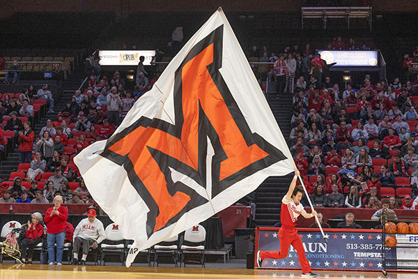 A Miami student with a Miami flag during a basketball game