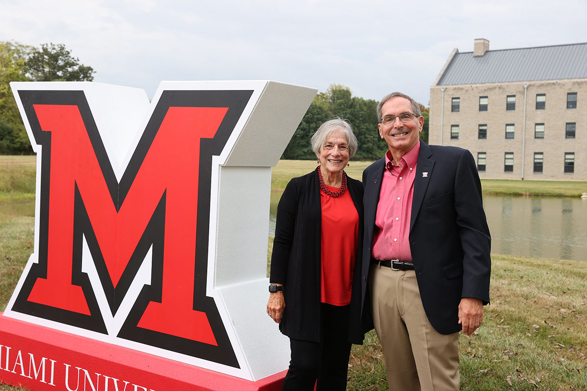 Graham and Sharon Mitchell stand next to a large beveled M near western upper pond