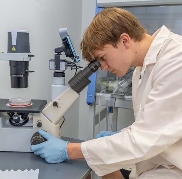 Stephen Mullally looks into a microscope 