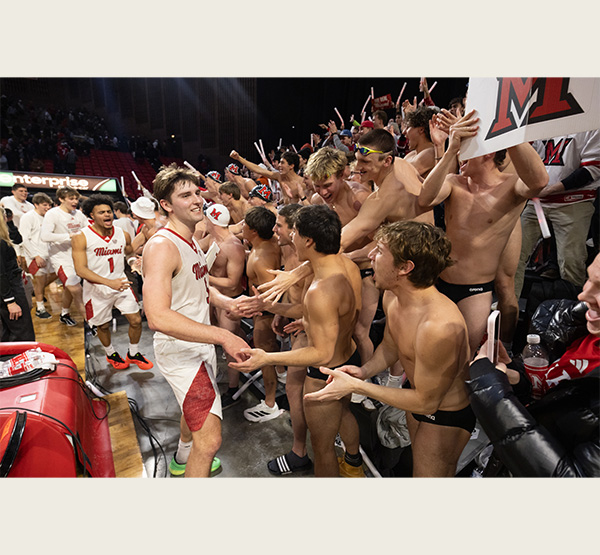 Miami University guard Peter Suder and other basketball players greet swimmers in the student section (photo by Scott Kissell).
