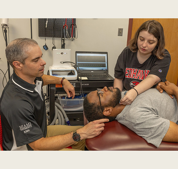 Hudak, with mentors Kevin Ballard  and Jon Stavres  practices her research skills in a lab in Phillips Hall 