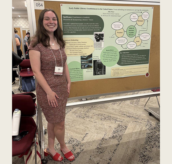 Julia Moser stands next to her undergraduate research poster at the Undergraduate research forum in Shriver Center 